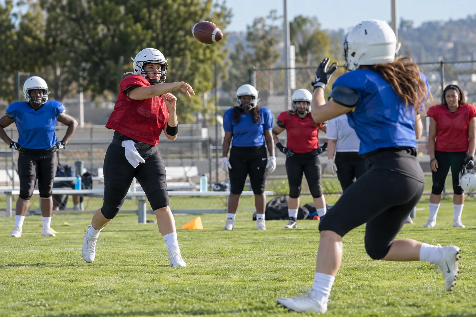 Illustration: Young adults take part in women's adult American football team practicing together.