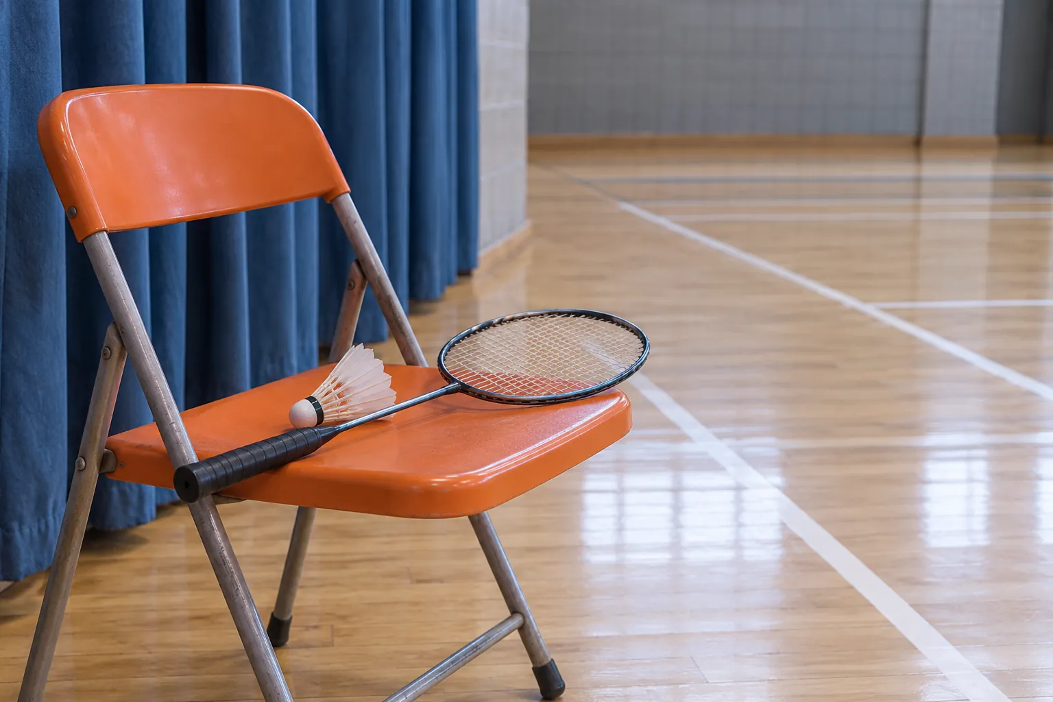 Illustration: A badminton racket and shuttlecock on an orange folding chair beside a blue curtain.