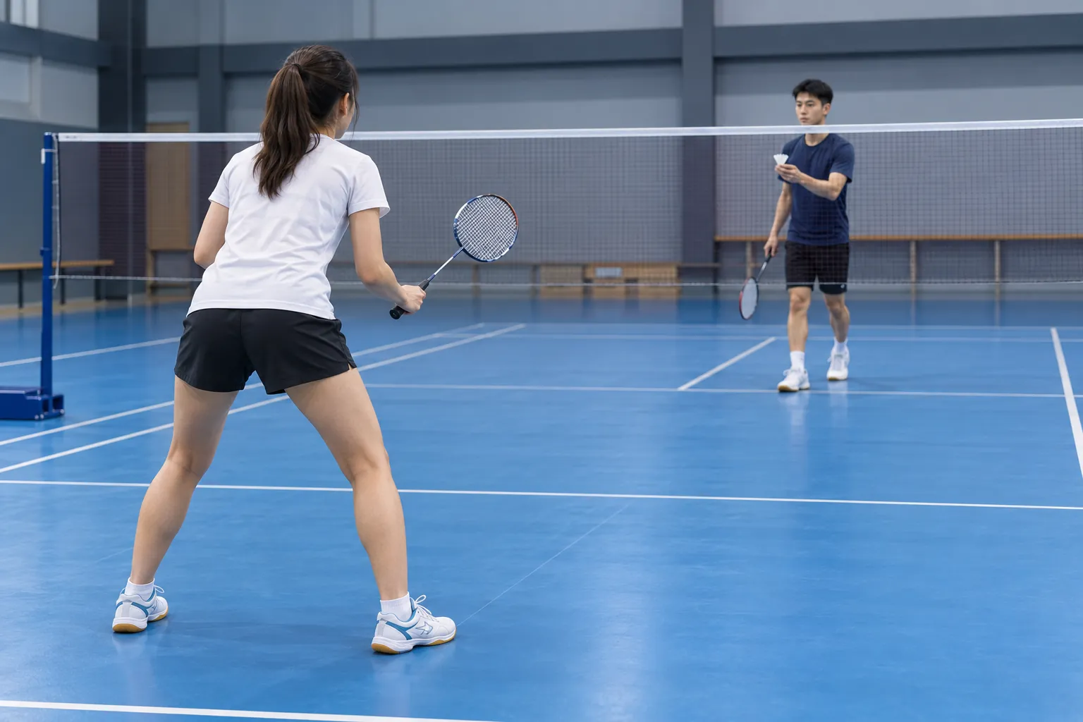 Illustration: Young adults prepare to rally on an indoor badminton court.