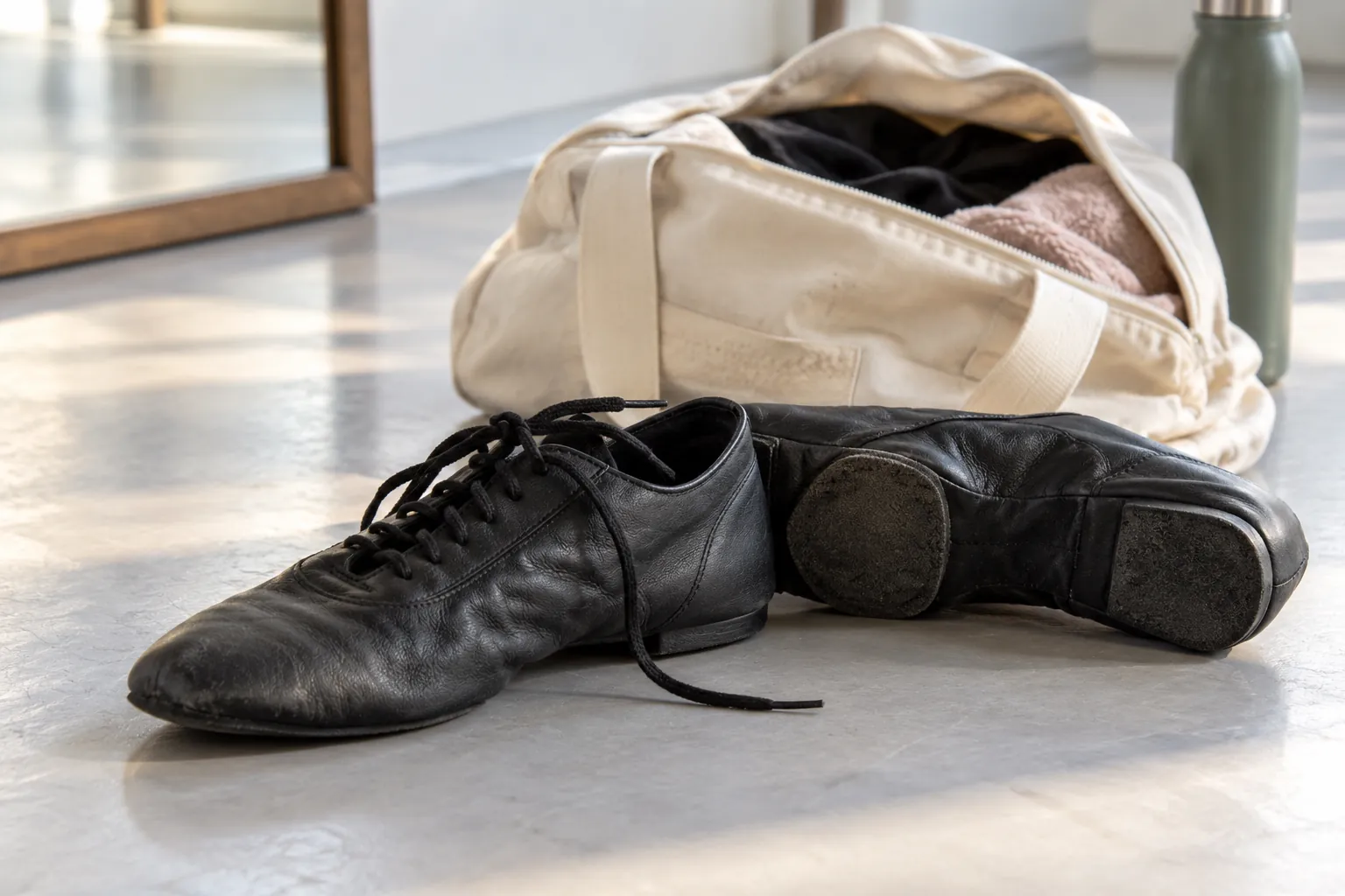 Illustration: Lace-up jazz shoes and a canvas practice bag on a studio floor.