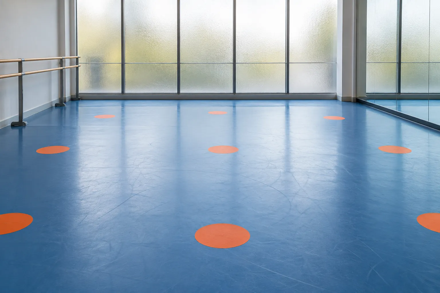 Illustration: Simple unnumbered orange circular floor spots are spaced across a blue studio floor for a group dance class, with no people and frosted glass behind, shown wide.