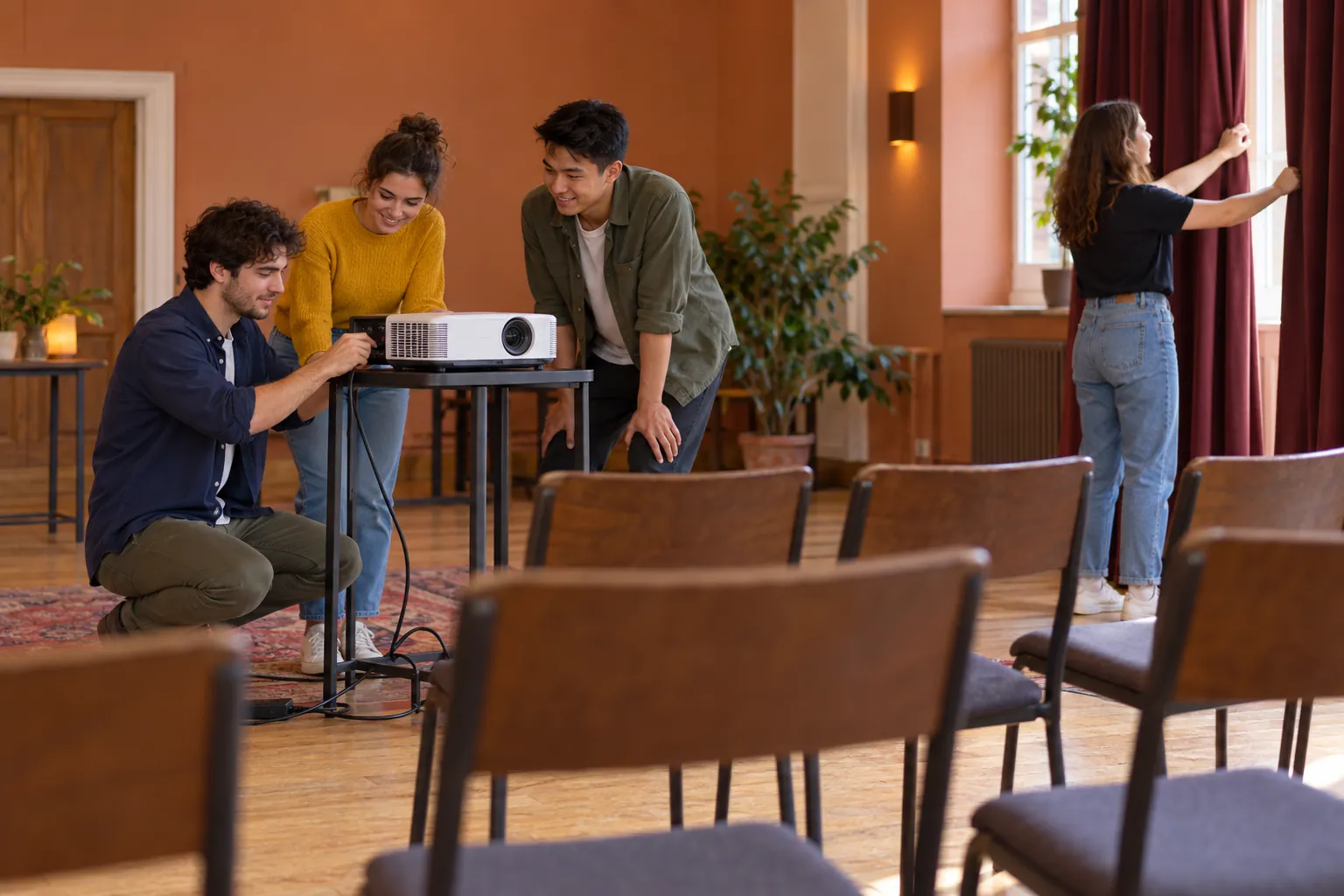 Illustration: Young adults setting up a projector in a community hall.