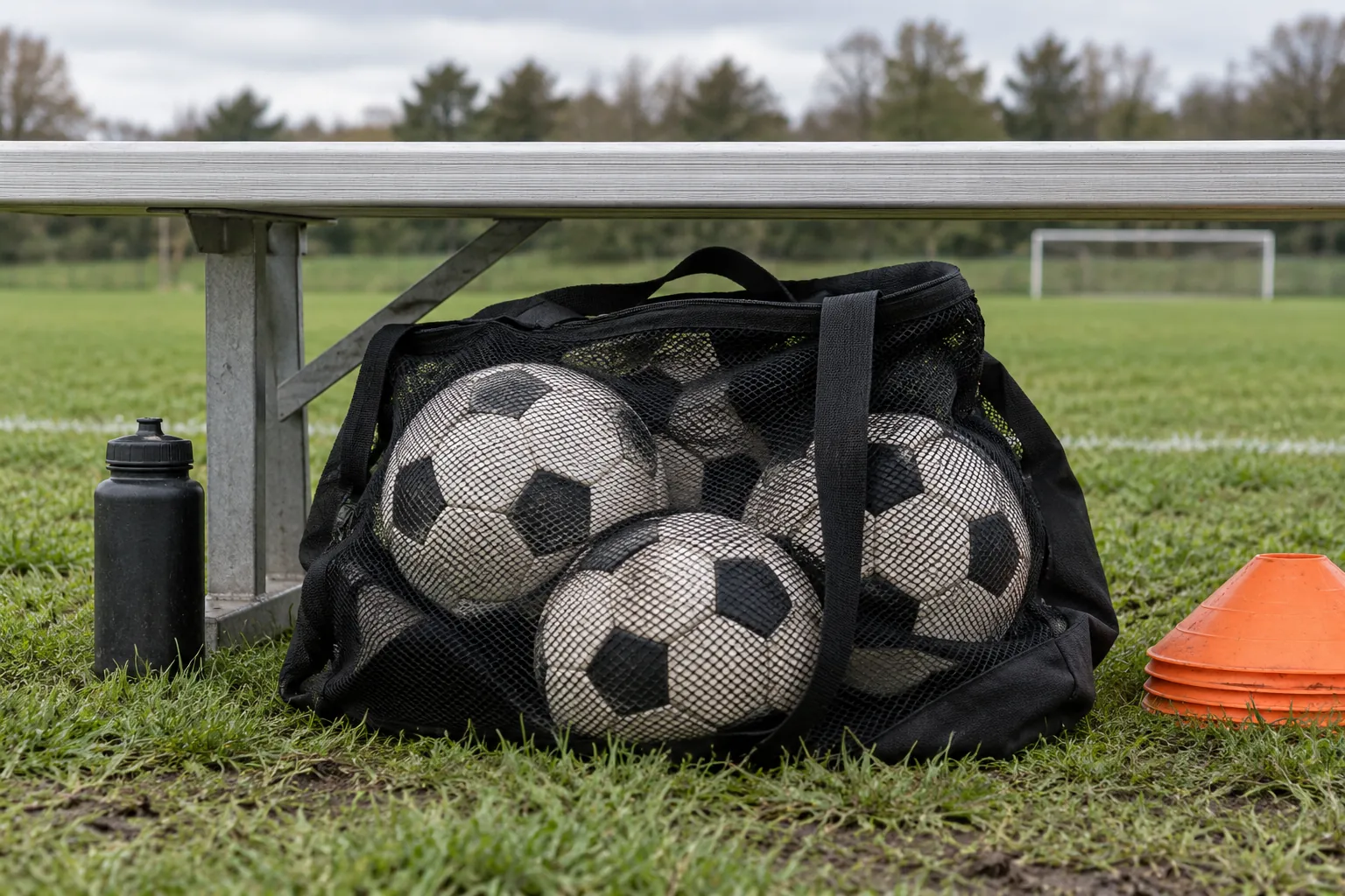 Illustration: A mesh bag of soccer balls beneath a field-side bench.