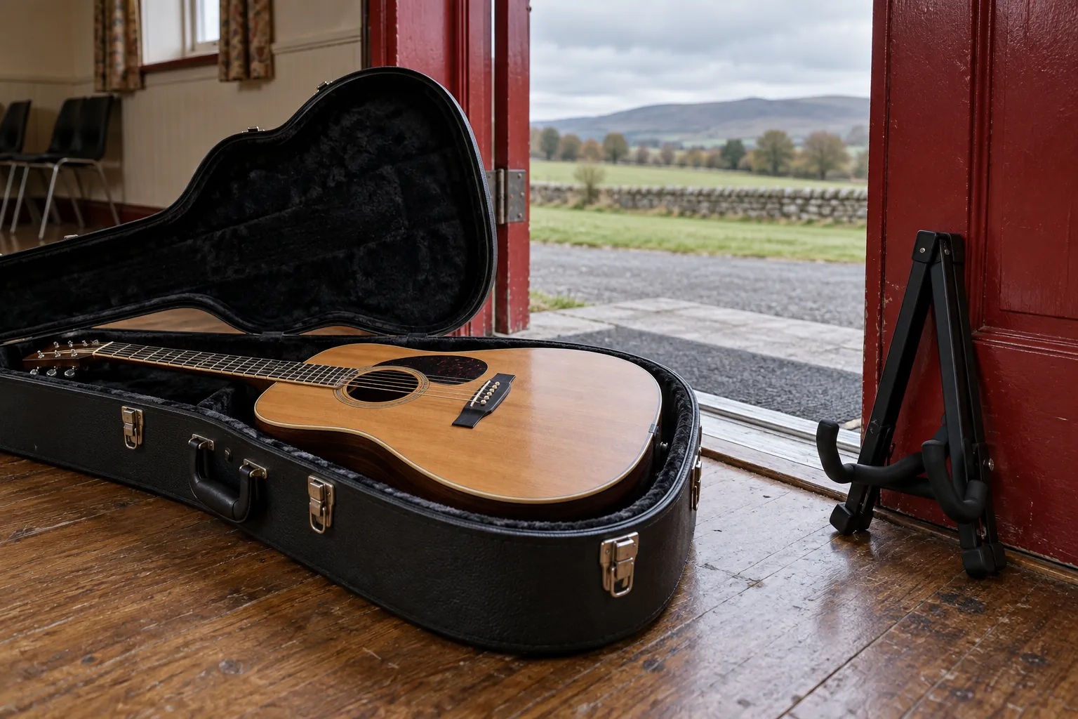 Illustration: An unbranded acoustic guitar in an open black case rests safely inside a red-painted community-room doorway beside a folded stand.