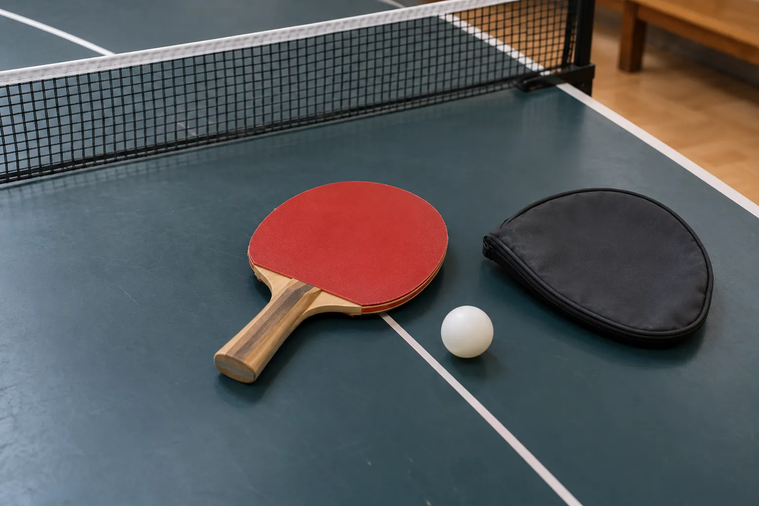 Illustration: A red-rubber paddle, protective cover sheet and white ball.