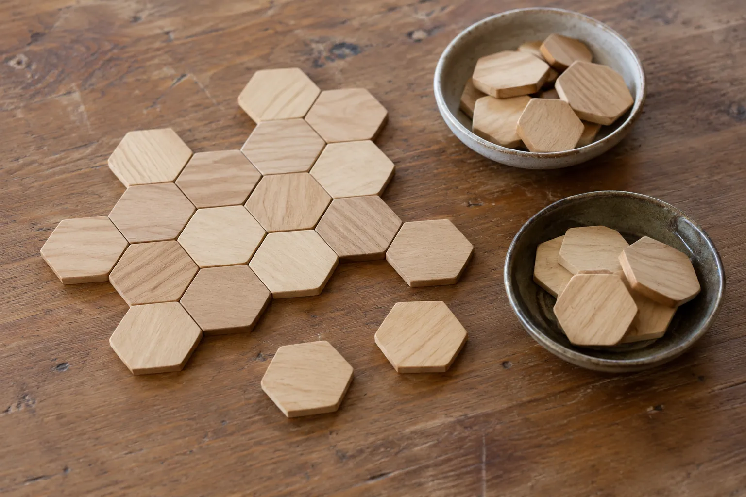 Illustration: Plain wooden hexagonal tiles and counter dishes on a table.