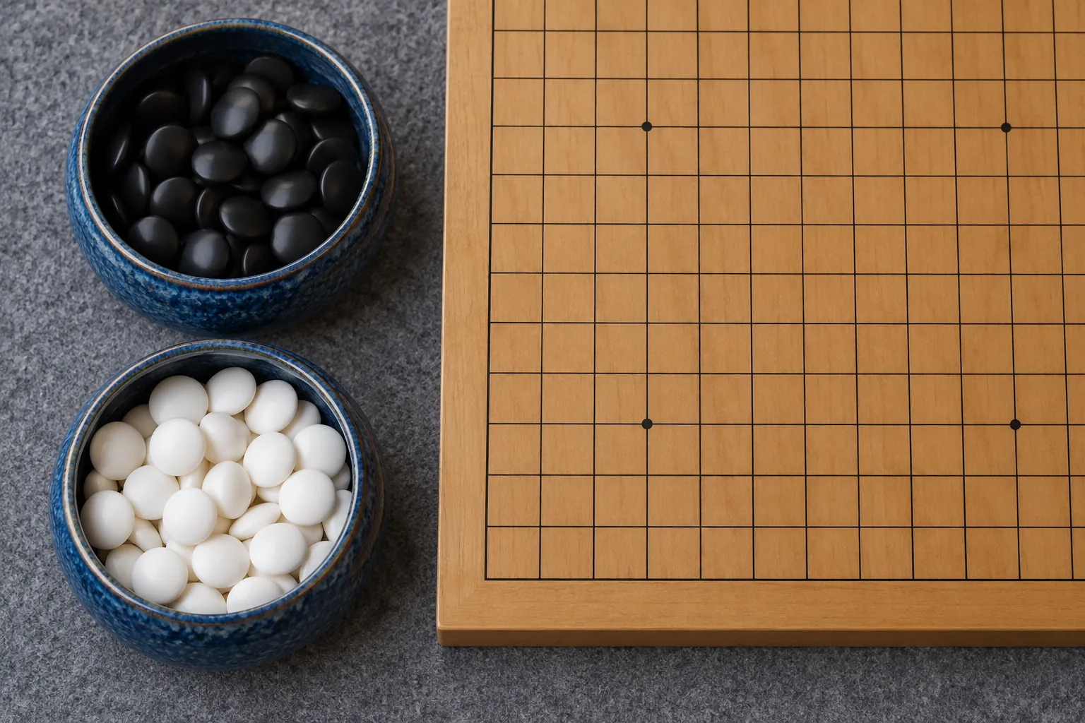 Illustration: Black and white Go stones sit in two blue ceramic bowls beside a cropped section of a correctly spaced square Go grid on a gray felt surface, seen overhead.