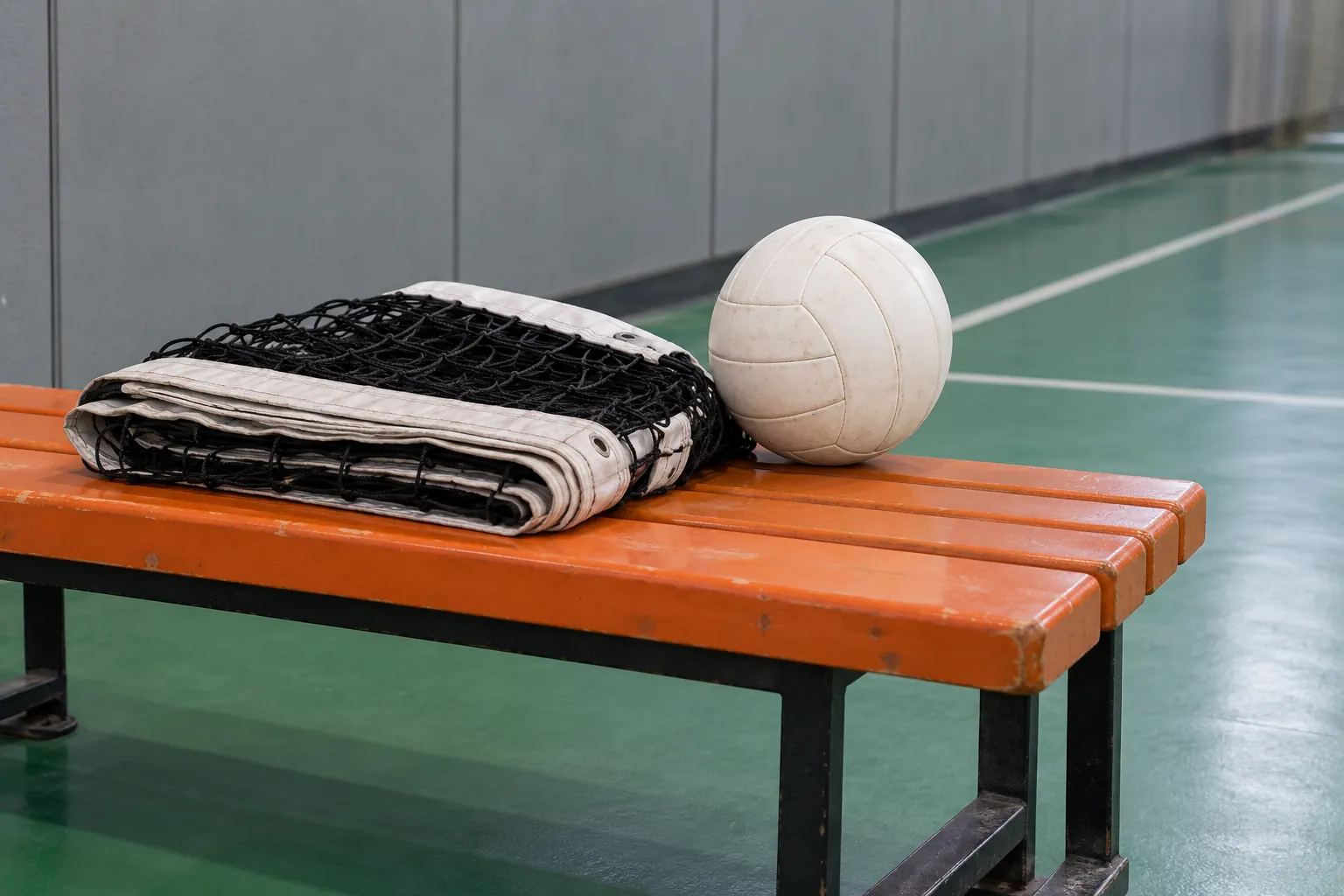 Illustration: A neatly folded volleyball net and a plain volleyball rest on an orange sports bench beside a green indoor court.